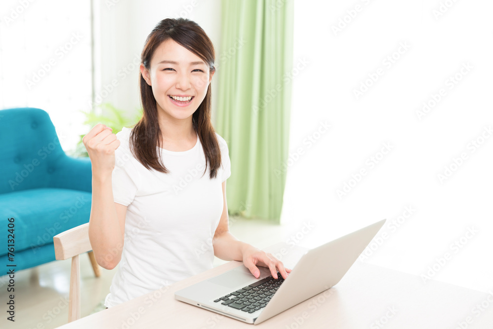 部屋でパソコンを使う女性