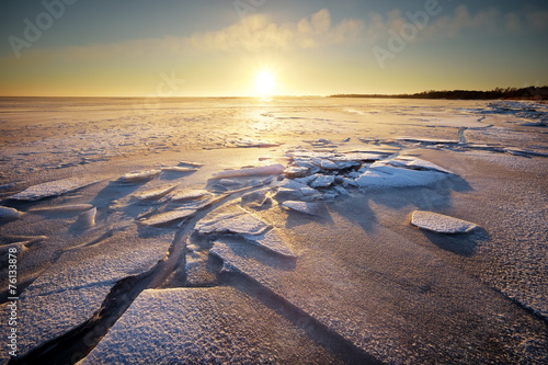 Winter landscape with lake and sunset fiery sky.