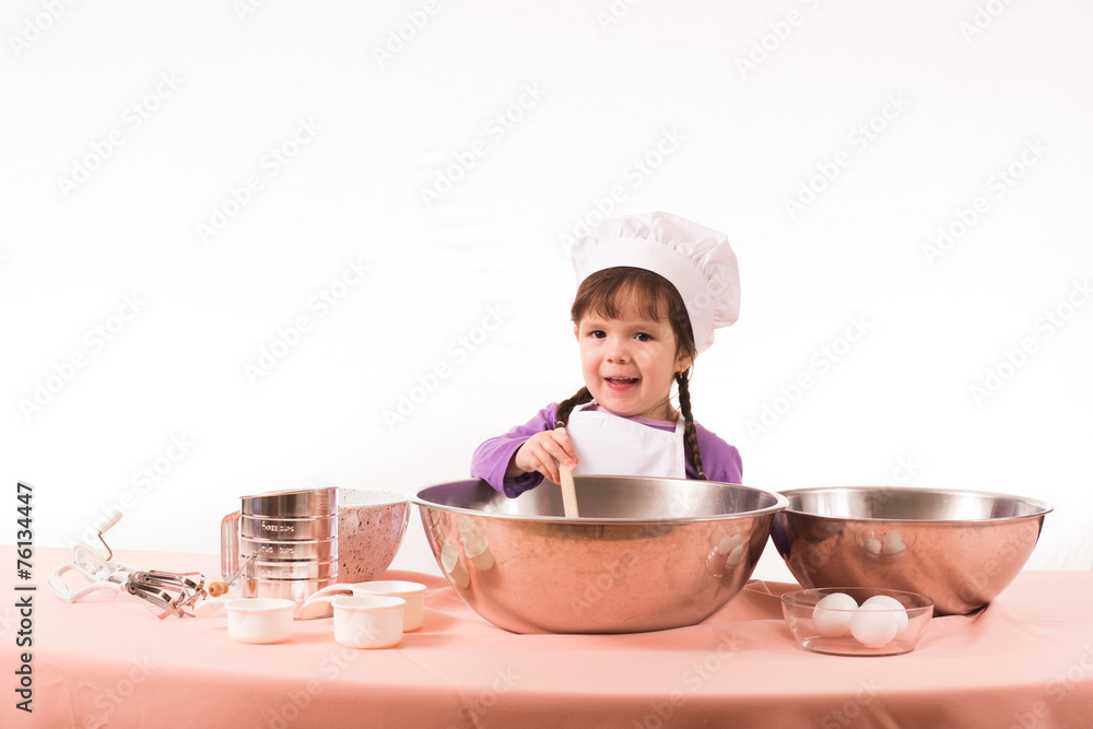 Little girl mixing ingrediets in a bowl. Little girl mixing ingrediets in a bowl.