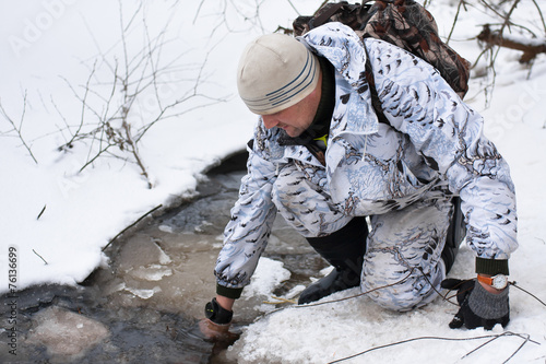 trapper pulls the trap out of the water
