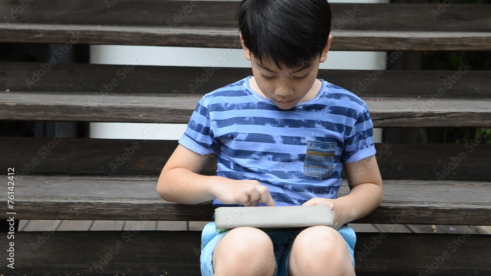 little Asian child using a digital tablet . little Asian child using a digital tablet .