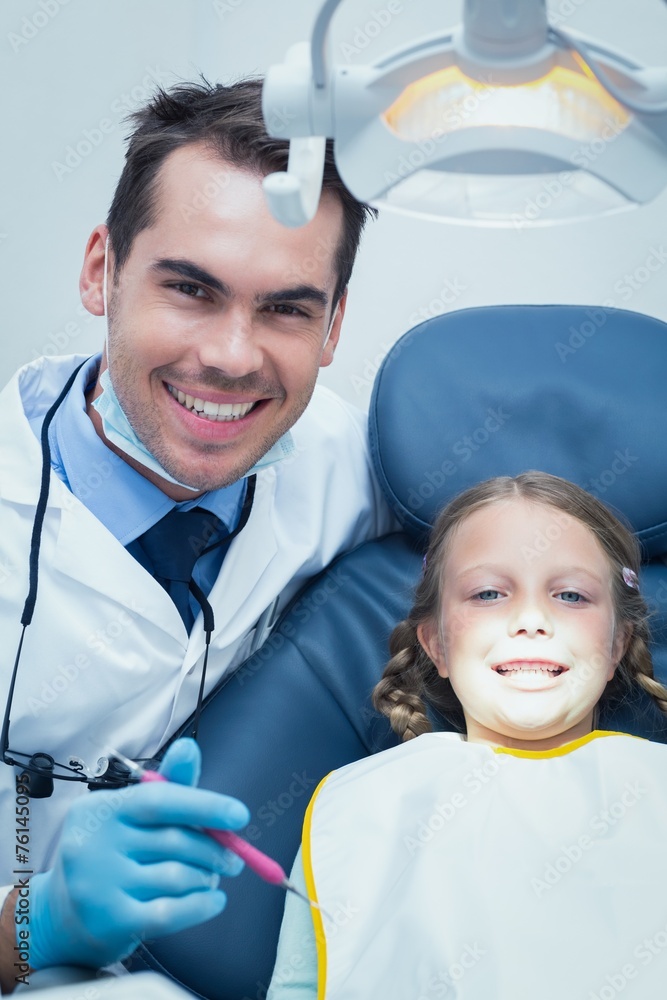 Male dentist examining girls teeth Male dentist examining girls teeth