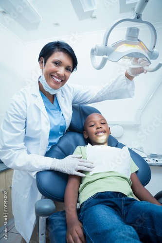 Female dentist examining boys teeth