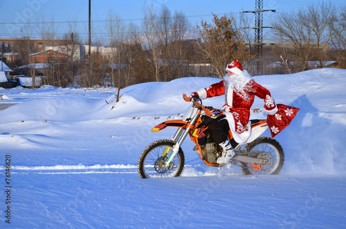 Santa Claus riding on a bike MX through deep snow
