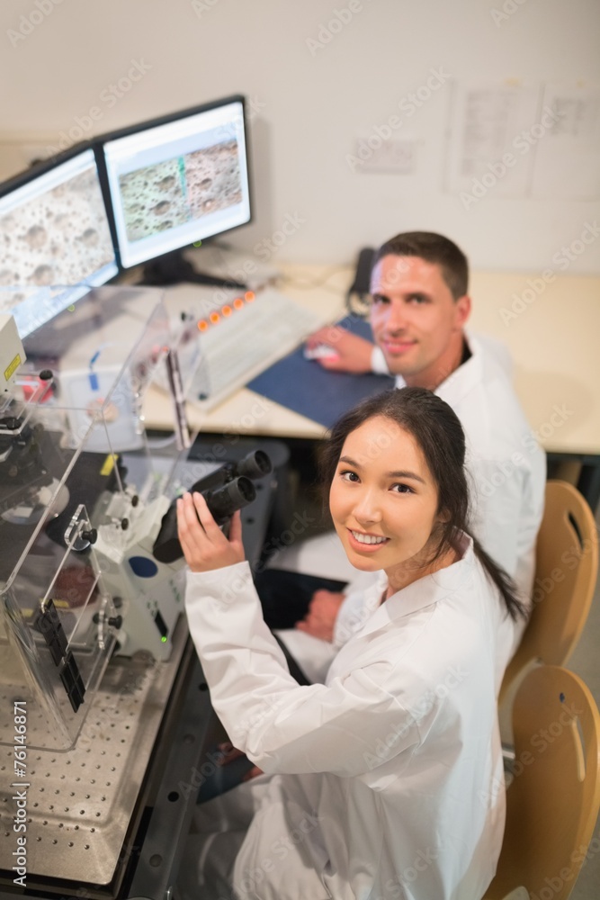 Fototapeta premium Biochemistry students using large microscope and computer