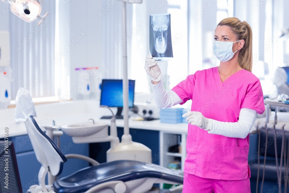 Dentist in surgical mask holding an x-ray Dentist in surgical mask holding an x-ray