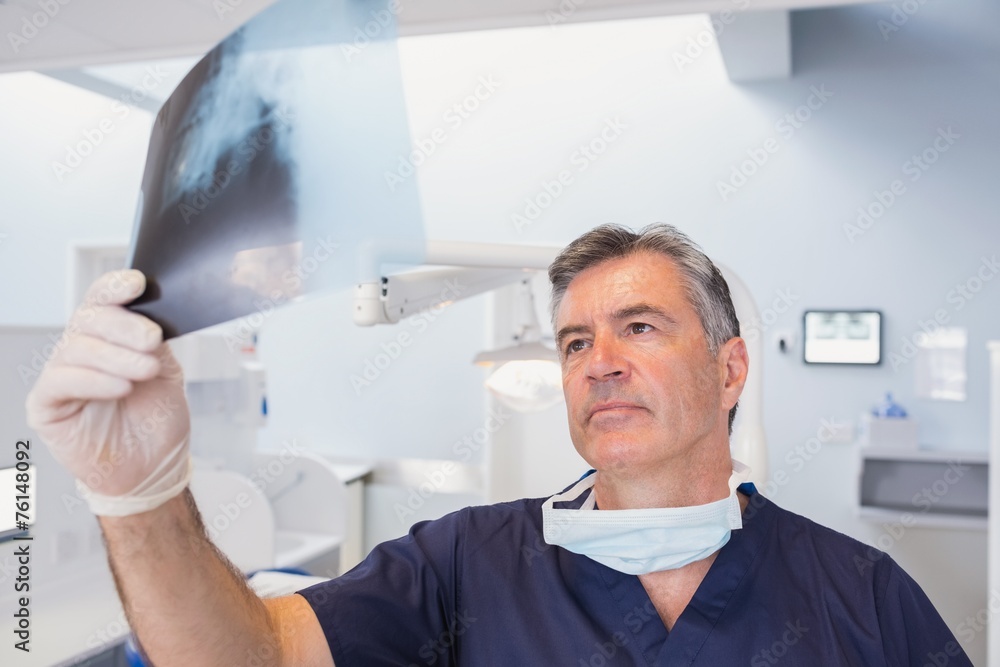 Serious dentist examining a x-ray Serious dentist examining a x-ray