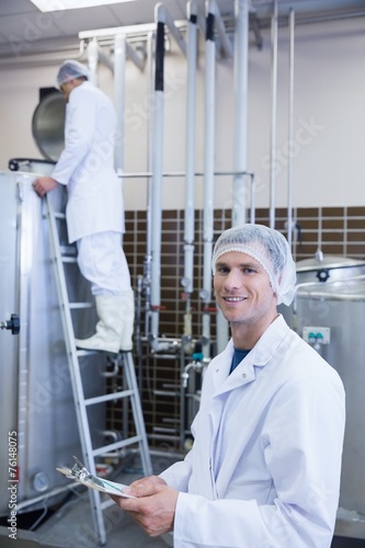 Scientist looking at camera with his colleague behind him