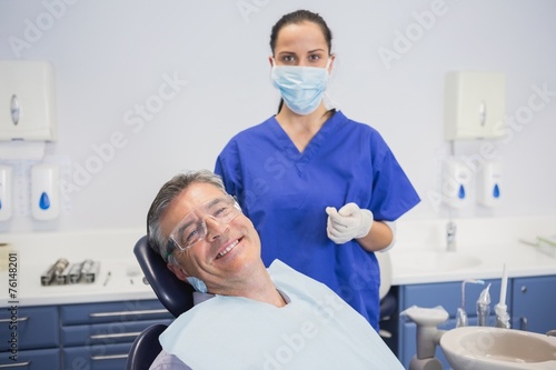 Dentist wearing surgical mask with a smiling patient