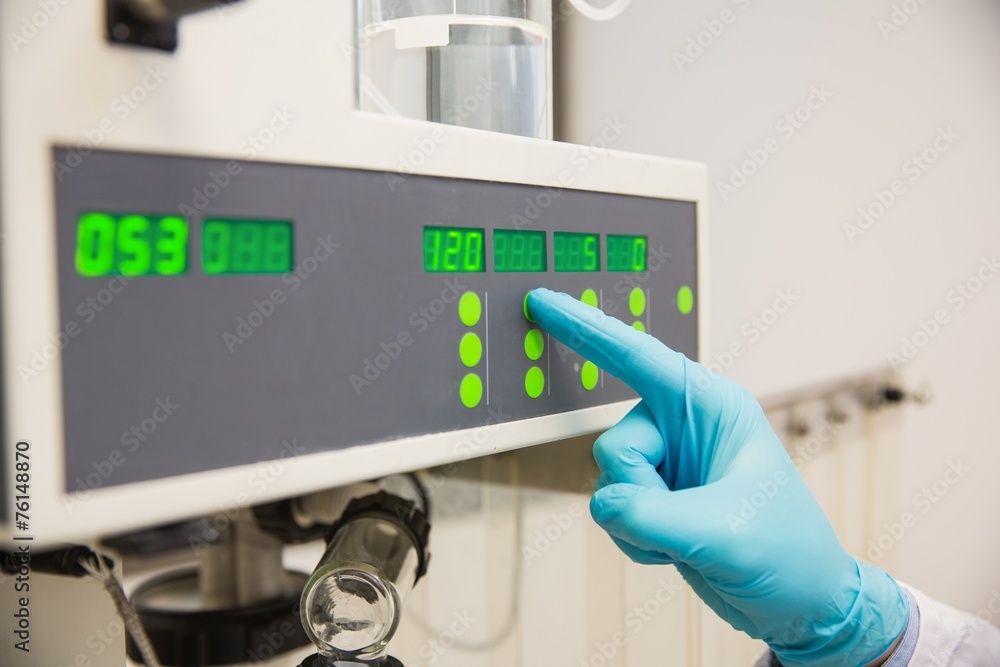 Pharmacist using machinery to make medicine Pharmacist using machinery to make medicine