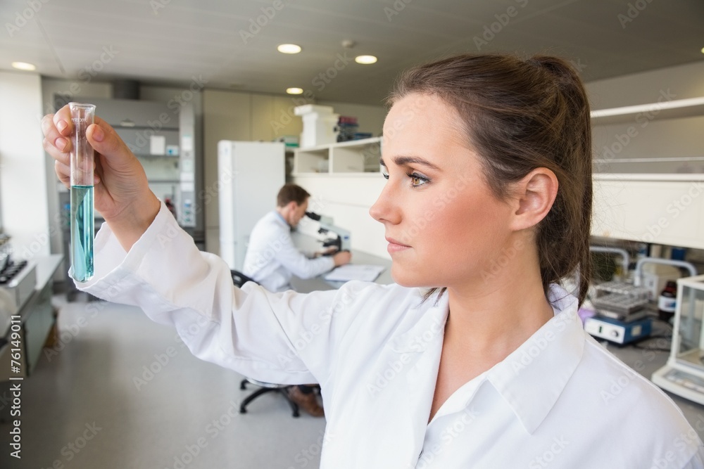 Young scientist holding up test tube Young scientist holding up test tube