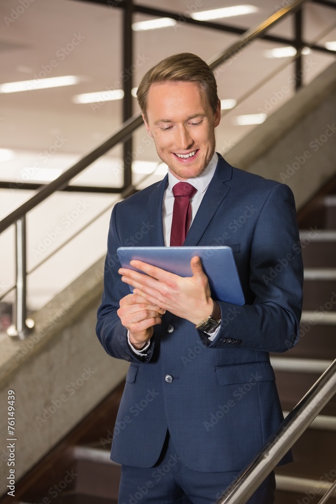 Handsome businessman standing on steps using tablet Handsome businessman standing on steps using tablet