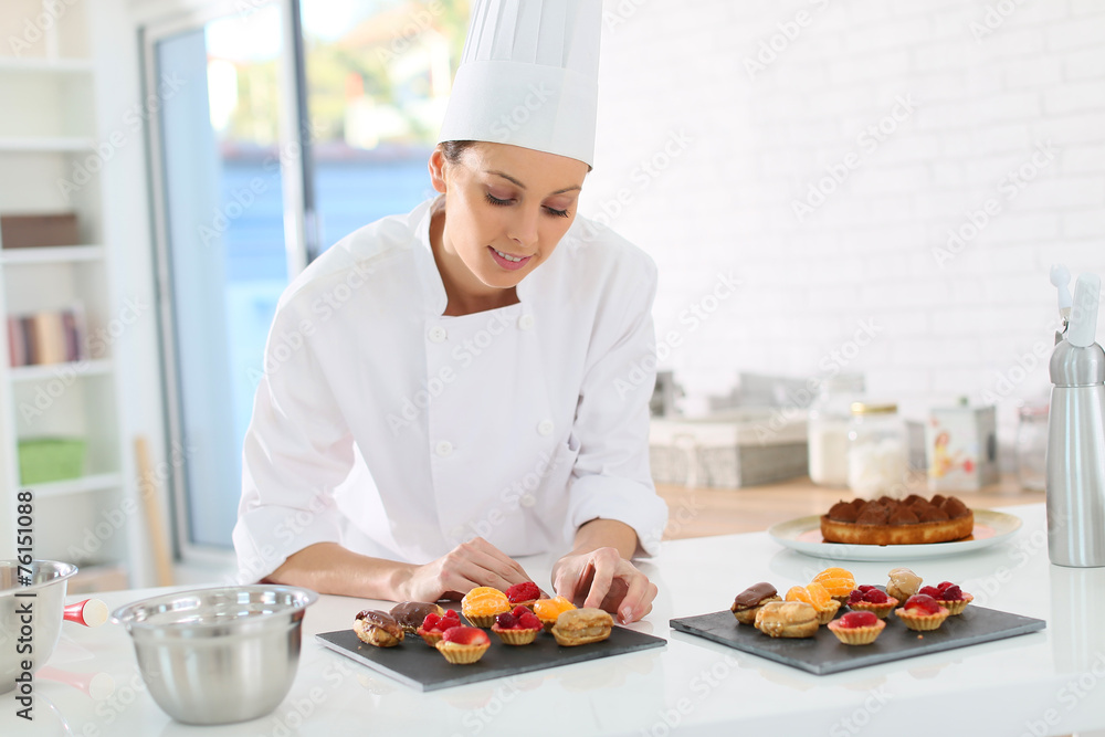 Pastry-cook preparing plate of cake bites Pastry-cook preparing plate of cake bites