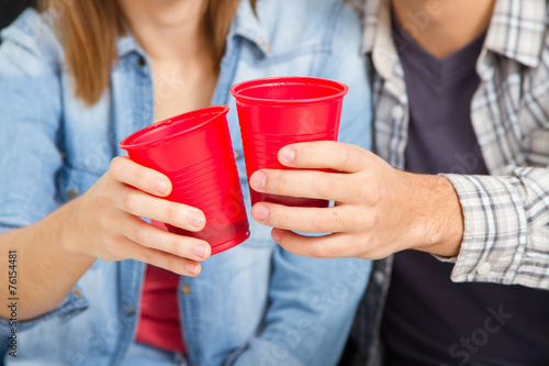Photography Closeup hands of friends toasting with red plastic cups