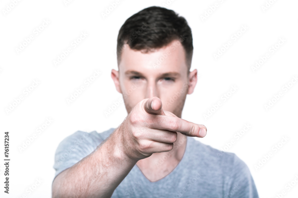 Confident young man pointing his finger to you Confident young man pointing his finger to you