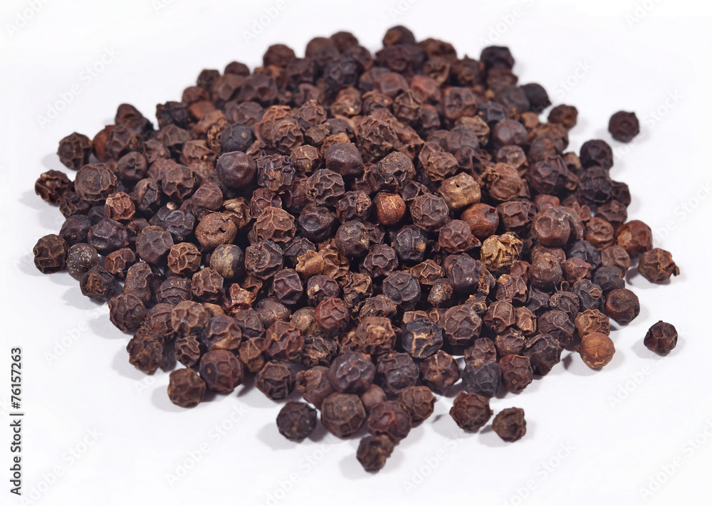 Heap of black pepper on a white Heap of black pepper on a white