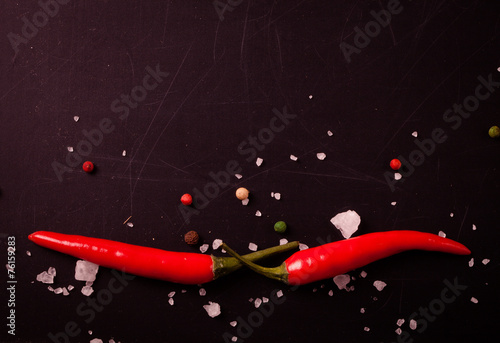Red hot chilli pepper with sea salt and colored pepper on black