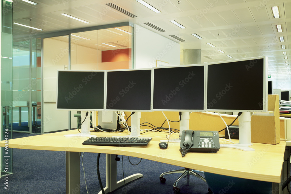 Computer desk with monitors in a modern office Computer desk with monitors in a modern office