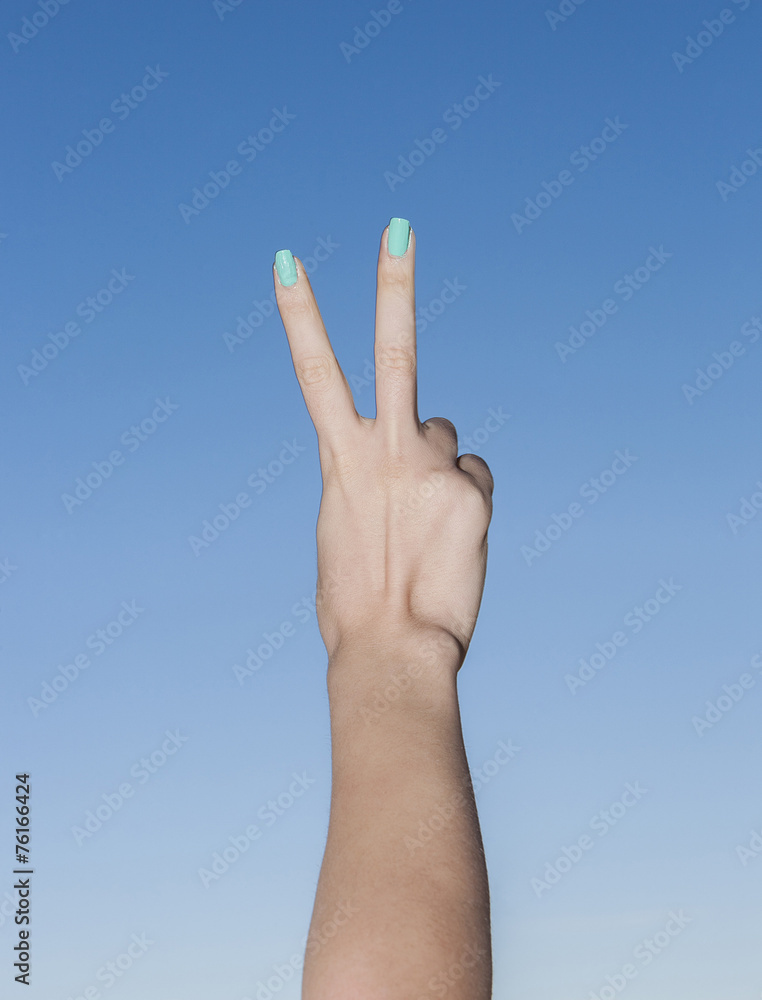 Female beautiful hand up in the sky making victory gesture Female beautiful hand up in the sky making victory gesture