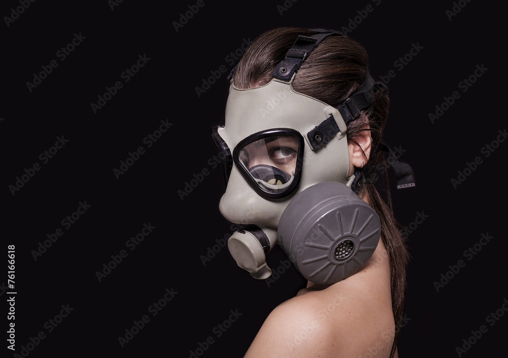Beautiful girl wearing gas mask and looking at camera