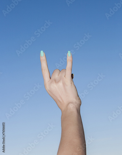 Hand up in the sky making sign of the horns