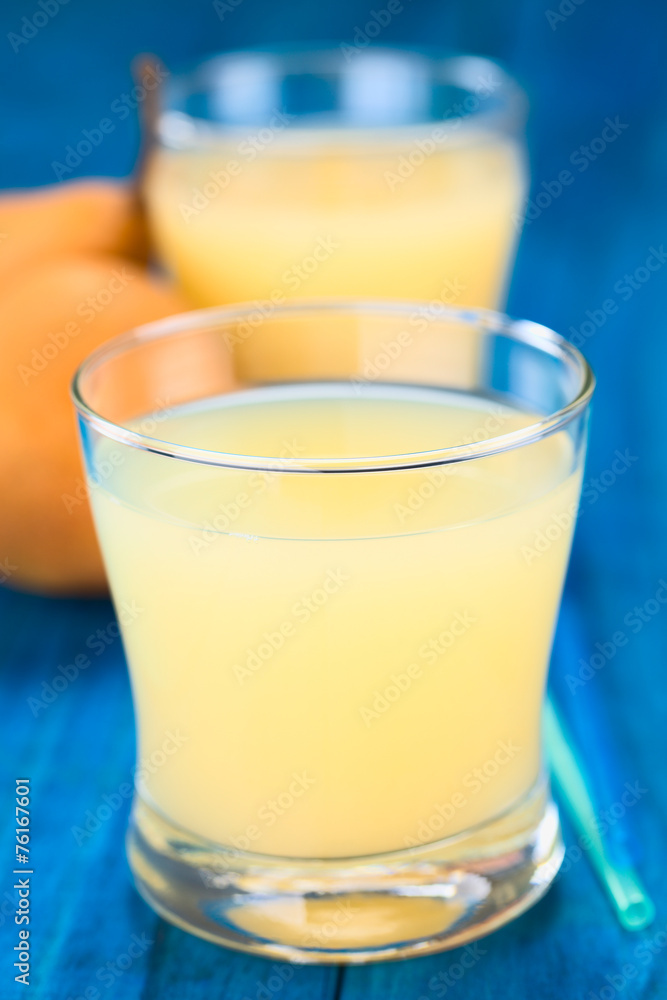 Pear juice in glass with drinking straws on the side Pear juice in glass with drinking straws on the side