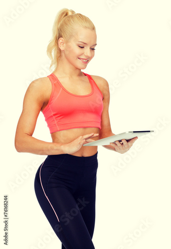 smiling sporty woman with tablet pc computer