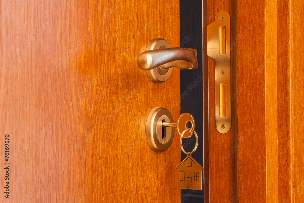Obraz premium open door with inserted key in the keyhole and house icon on it