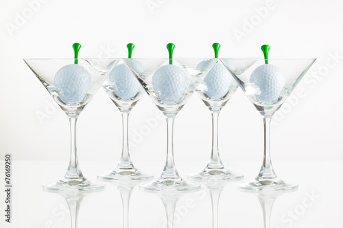 Five glasses of champagne and golf equipments