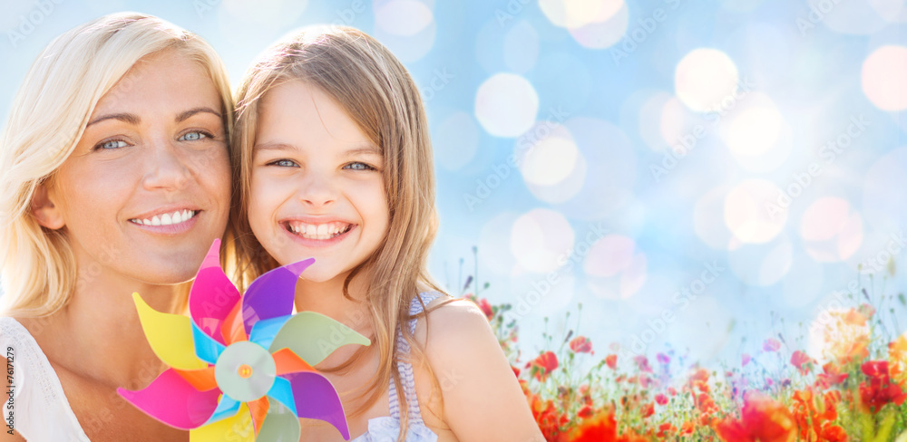 happy mother and little girl with pinwheel toy happy mother and little girl with pinwheel toy
