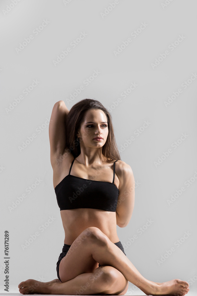 Athletic yogi girl in sportswear practices yoga asana, Gomukhasa Athletic yogi girl in sportswear practices yoga asana, Gomukhasa