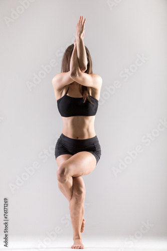 Yogi gymnast girl doing asana Garudasana, Eagle Pose photo