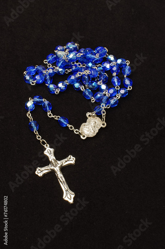 Blue glass rosary isolated on the dark background