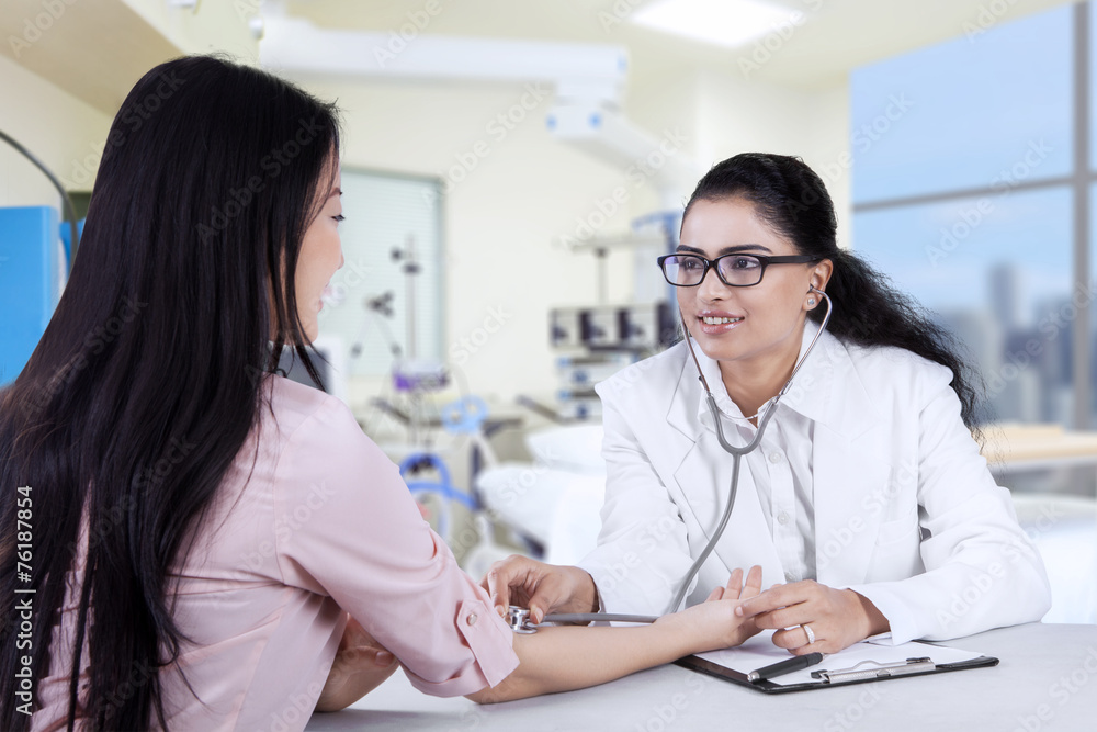 Fototapeta premium Asian doctor listening the patient heartbeat