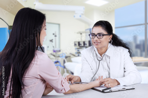 Asian doctor listening the patient heartbeat
