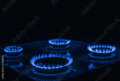 Blue flames of gas burning from a kitchen gas stove with space f