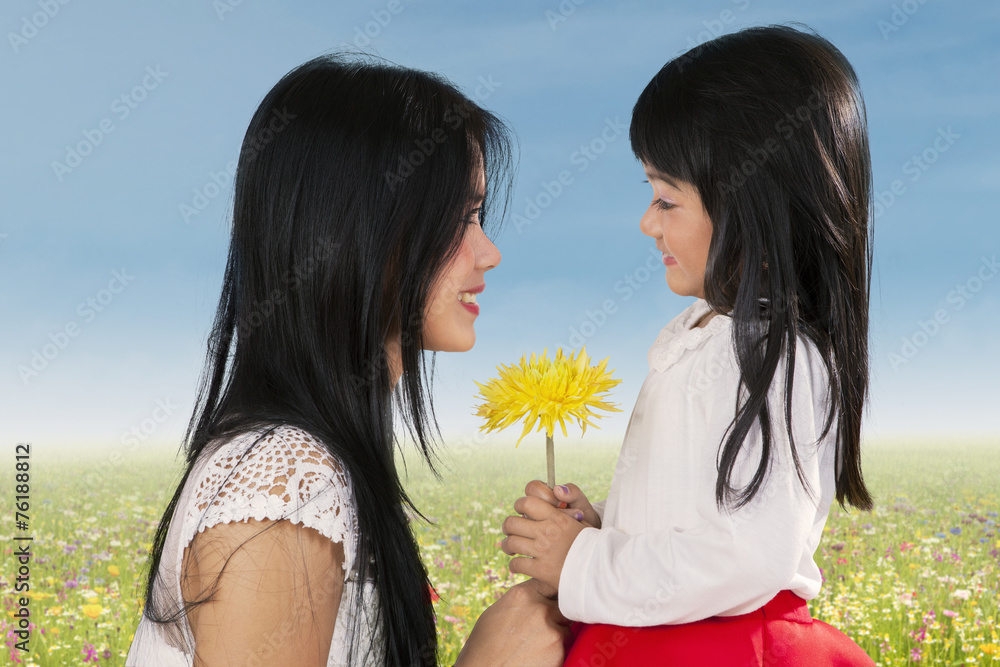 Cute girl giving flower to her mom Cute girl giving flower to her mom