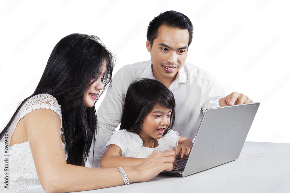Happy parents using laptop with their child