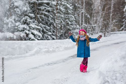 Little girl hamming and playing in the winter forest © Cliplab
