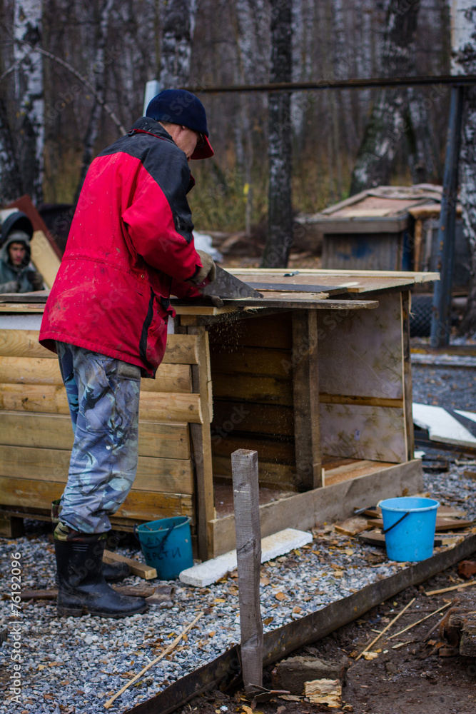 man sawing a wooden board man sawing a wooden board