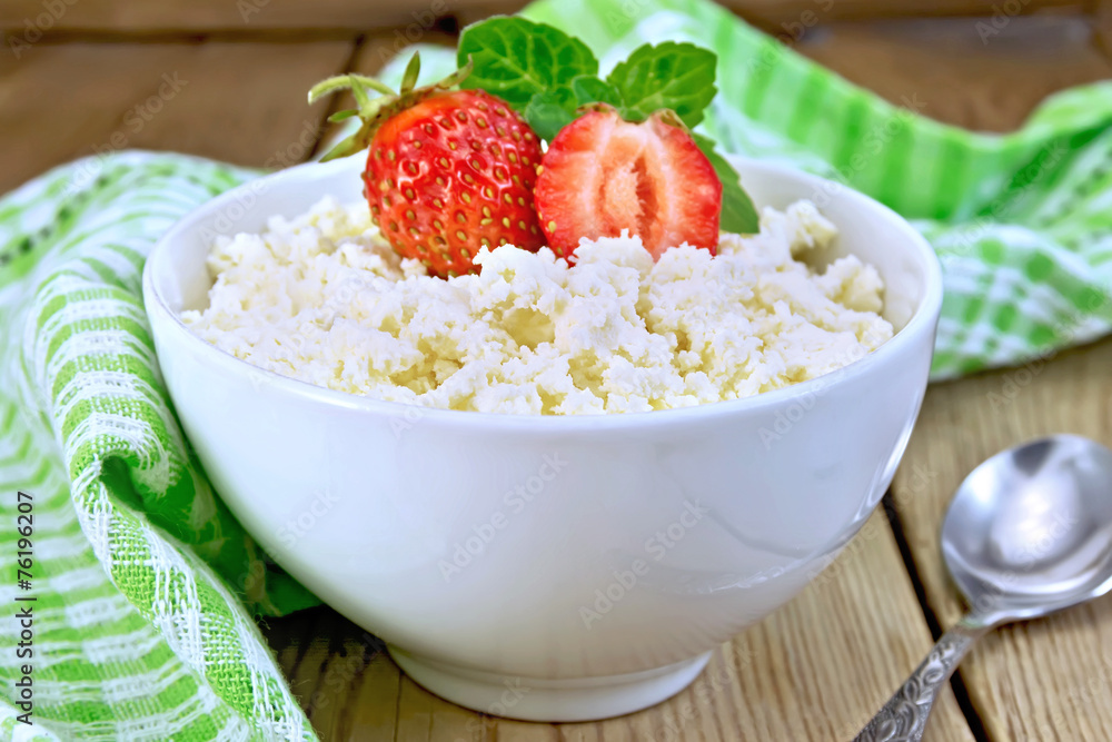 Curd with strawberries in white bowl on board Curd with strawberries in white bowl on board