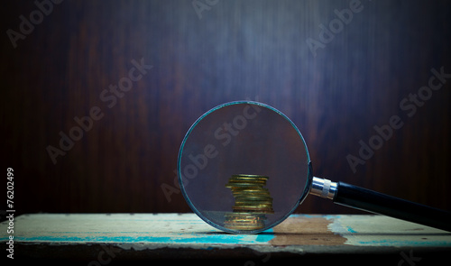 Magnifier and gold coins. photo