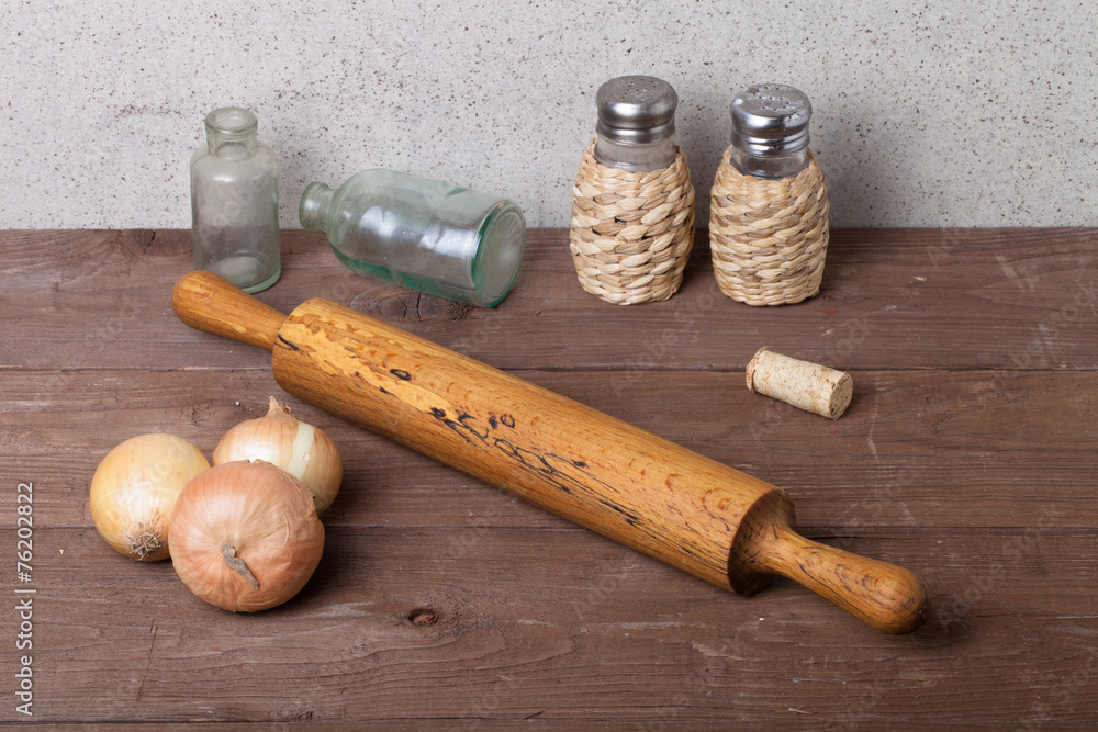 Onion, salt, pepper, rolling pin, old bottles and cork on the ol