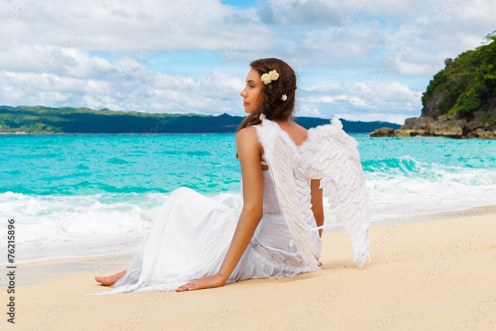 Beautiful young bride with angel wings on the sea coast. Tropica Beautiful young bride with angel wings on the sea coast. Tropica