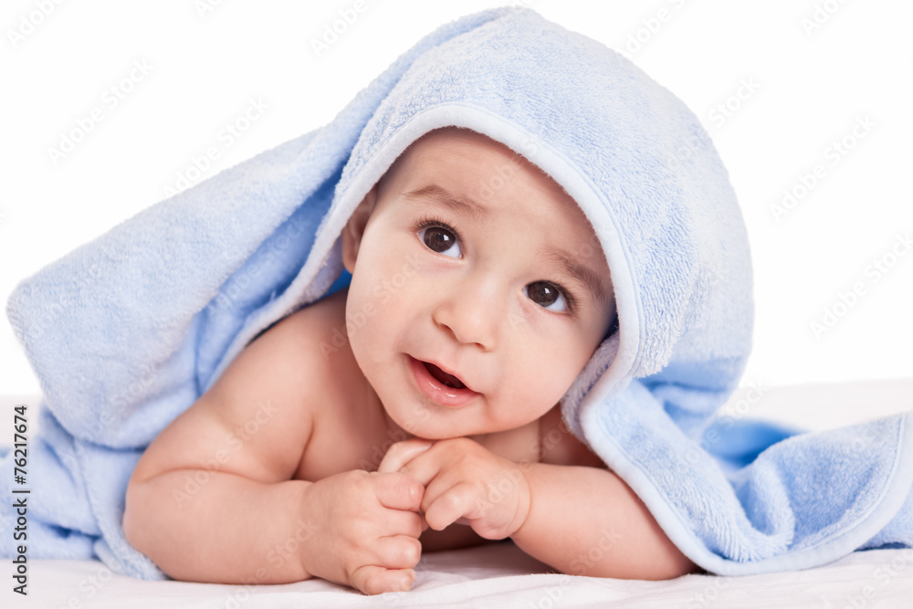 Cute gently baby lying on bed with blue towel Cute gently baby lying on bed with blue towel