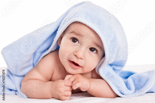 Cute gently baby lying on bed with blue towel