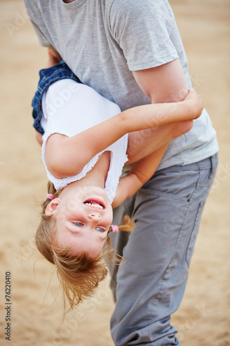 Vater tobt mit Tochter am Strand photo