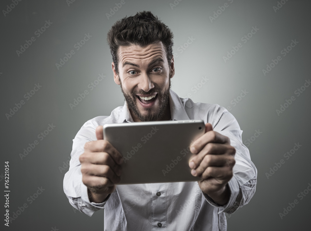Cheerful man watching videos on tablet Cheerful man watching videos on tablet