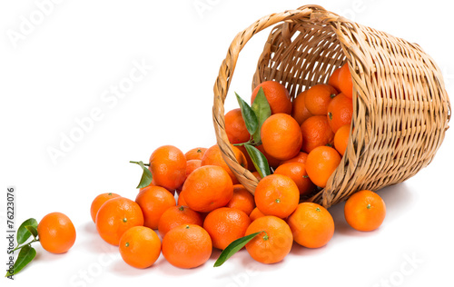 underlying basket with tangerines spilling on a white