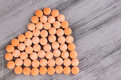 Heart of pills on wooden background